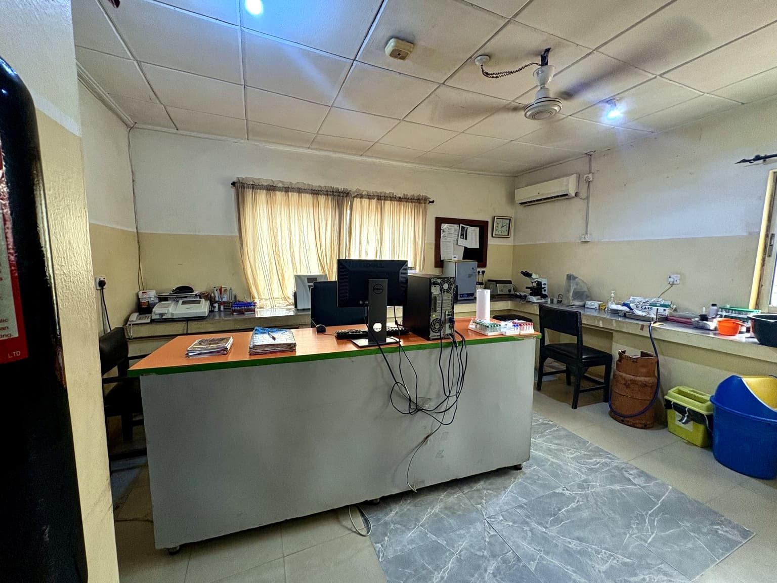 Laboratory at Banby Specialist Hospital in Ibadan, with analysers and a microscope along the bench and sample racks at the counter